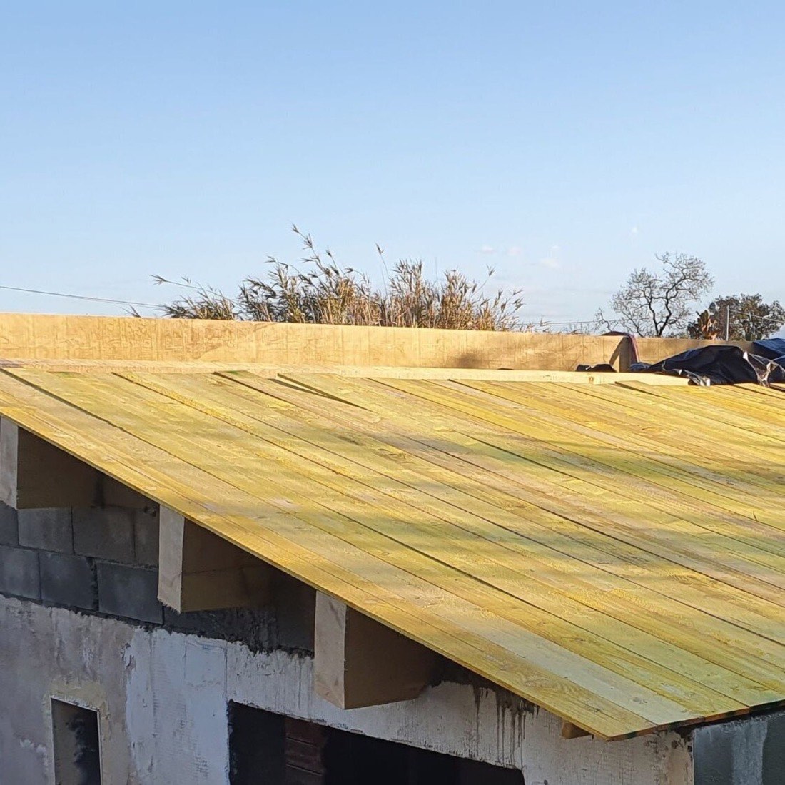Couverture bois posée sur la structure d'un garage en construction.