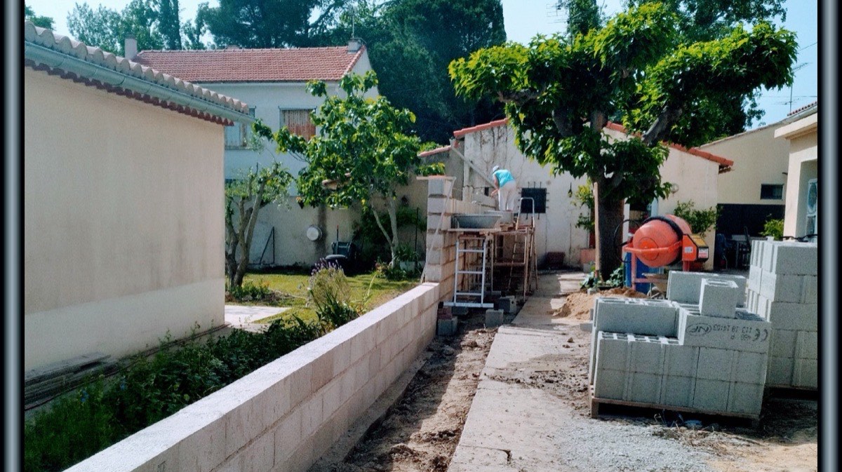 Élévation d'un mur en blocs béton sur un chantier de maçonnerie à Arles.