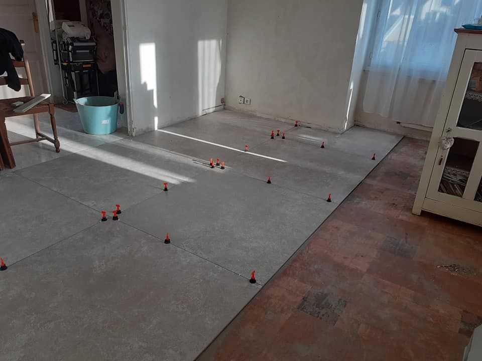 Pose de carrelage grand format sur un ancien sol, avec croisillons autonivelants.